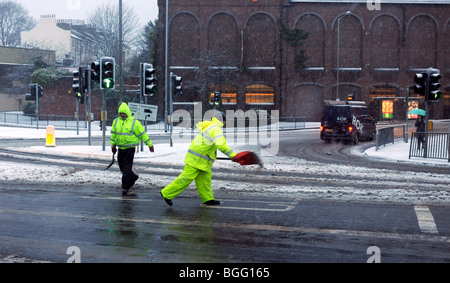 Les travailleurs du conseil de diffusion de la granulation et le sel à la main sur les routes durant une tempête de neige à Brighton, UK Banque D'Images