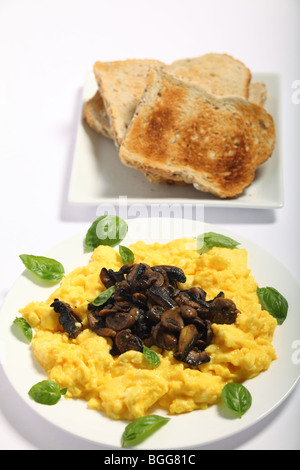 Vue verticale d'un petit-déjeuner gastronomique d'œufs brouillés, de champignons et pain grillé Banque D'Images