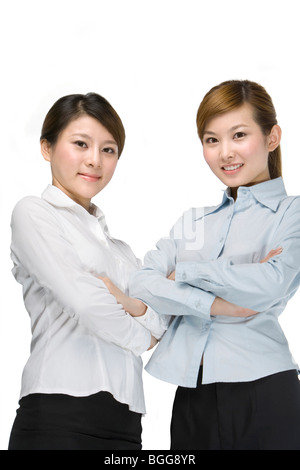 Les jeunes femmes se tenant ensemble, les bras croisés Banque D'Images