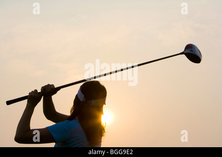 Silhouette de golfeur au coucher du soleil Banque D'Images