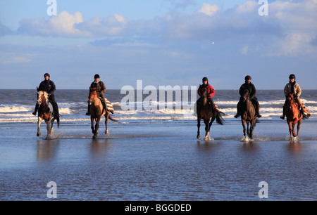 Cinq cavaliers sur la plage Équitation à Burnham Overy de Holkham le jour de l'an 2010. Banque D'Images