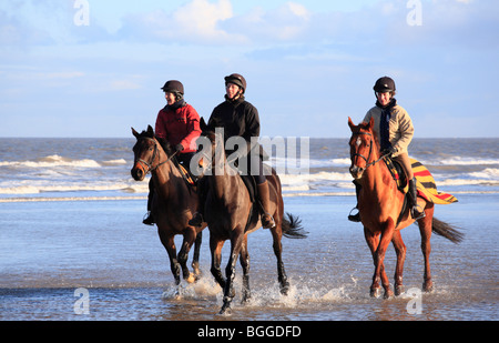 Trois cavaliers sur la plage Équitation à Burnham Overy de Holkham le jour de l'an 2010. Banque D'Images