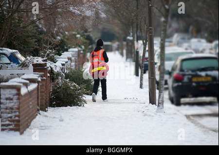 Postman livrer le courrier en hiver Banque D'Images