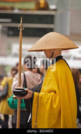 Main outstreched moine vagabond japonais pour l'aumône. Shibuya, Tokyo, Japon Banque D'Images