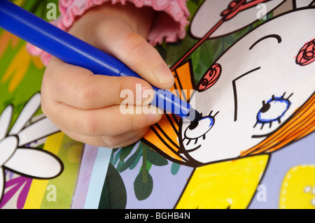 Stock photo d'un enfant de quatre ans pour les mains dans une image à colorier. Banque D'Images