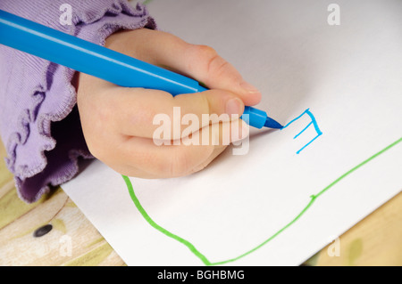 Stock photo d'un gros plan d'une petite filles main tenant un feutre qu'elle dessine une photo. Banque D'Images