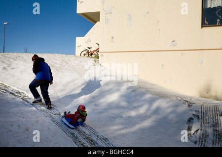 Mère et son garçon jouer dans la neige. Hafnarfjordur, une plus grande région de Reykjavik, sud-ouest de l'Islande. Banque D'Images