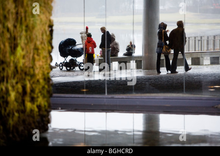 Une famille bénéficiant d'un pique-nique à l'extérieur pendant un jour pluvieux et brumeux. Hôtel de ville de Reykjavik, le centre-ville de Reykjavik, Islande. Banque D'Images