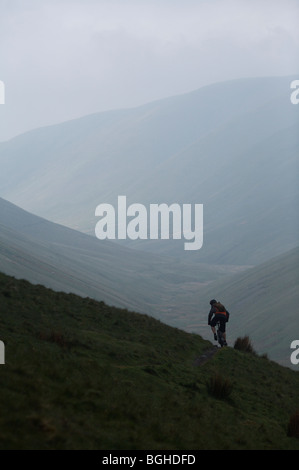 Des promenades en vélo de montagne d'un sentier de montagne brumeuse à Fells Cap Sud, Royaume-Uni Banque D'Images