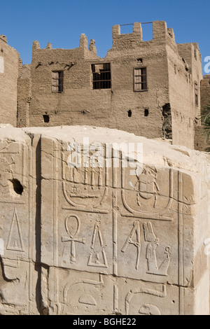 Mur de barque de culte en avant du village moderne maison à Le Temple de Montu à Tod, vallée du Nil, au sud de Louxor, Egypte Banque D'Images