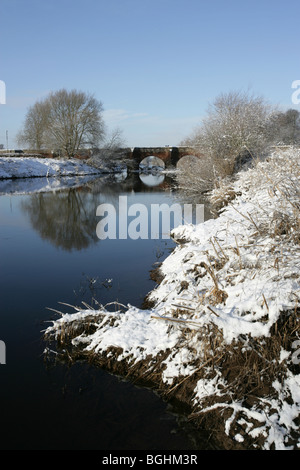 Village de Holt, le Pays de Galles. Vue pittoresque de la rivière Dee par une froide journée d'hiver enneigée, avec Holt Bridge en arrière-plan. Banque D'Images