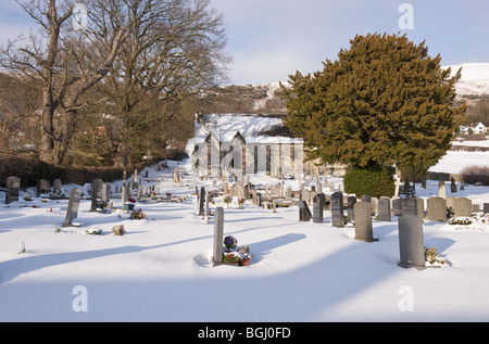 La neige a couvert petit village church et cimetière en milieu rural Banque D'Images