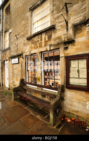 BURFORD, OXFORDSHIRE, Royaume-Uni - 31 OCTOBRE 2009 : ancien banc en bois à l'extérieur de la boutique Banque D'Images