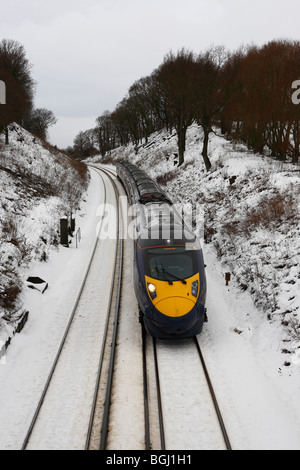 Un train à grande vitesse Javelin Hitachi se précipiter à travers la campagne d'hiver enneigés Kent en Angleterre Banque D'Images