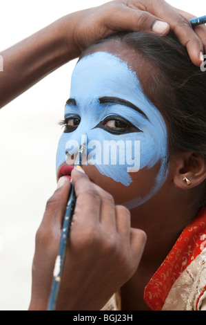 Indian girl ayant son visage peint en bleu pour être constitué comme une divinité de l'Inde. L'Andhra Pradesh, Inde Banque D'Images