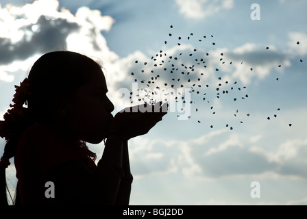 Indian girl blowing amour coeur dans l'air. L'Inde. Silhouette Banque D'Images