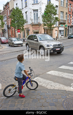 Jeune garçon sur un vélo en attente de cross road Banque D'Images