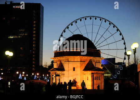 La grande roue en Centennary Square, Birmingham, qui donne le plaisir des manèges, vu avec le Temple de la mémoire, le premier plan, au crépuscule. Banque D'Images