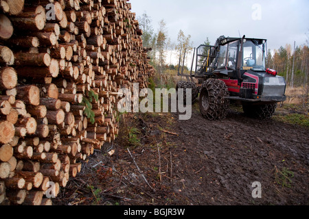 Valmet 840 abatteuse forestière ancienne et un tas de bois de sciage de pin ( Pinus sylvestris ) , Finlande Banque D'Images