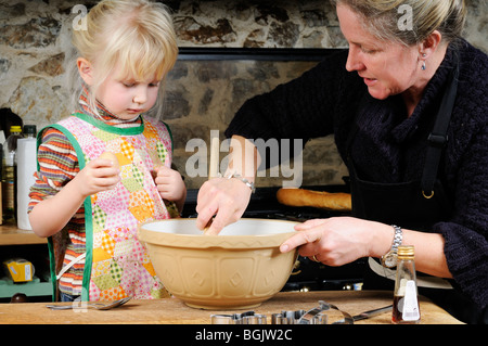 Stock photo d'une mère et sa fille mélange la pâte dans un bol. Banque D'Images