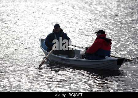 Silhouettes de deux hommes dans un petit barque / skiff , Finlande Banque D'Images