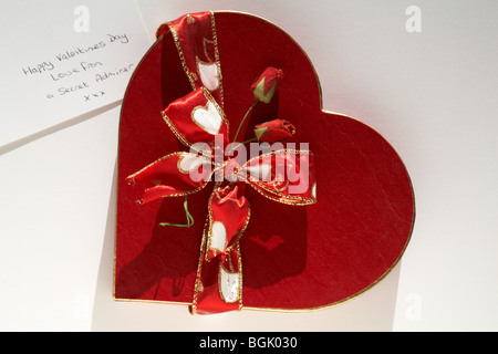 Cerclée d'or en forme de cœur rouge boîte avec du ruban et des roses rouges et message de l'admirateur secret pour un Happy Valentines Day, Valentine day Banque D'Images