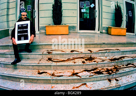 PARIS, France - militants de N.G.O. Act Up-Paris, Man Holding Sign, protestant en dehors du siège social de la société socialiste, manifestation LGBT, manifestations, FAIRE MONTER des manifestants, agir en signe de silence de protestation, faire du sang factice sur les marches vers les bureaux Banque D'Images