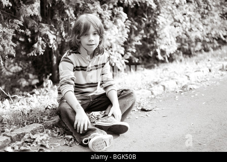 Garçon assis sur l'allée Banque D'Images