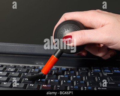 Coup de main de femme libre de balayer la poussière de clavier d'ordinateur portable à l'aide de l'ampoule de l'air Banque D'Images