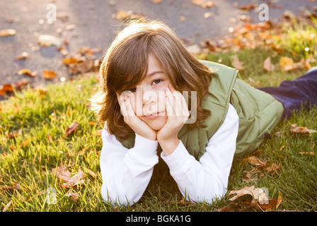 Boy lying in grass Banque D'Images