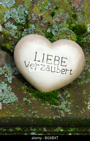 Coeur de pierre avec les mots 'Liebe verzaubert', l'allemand pour 'Amour' enchante Banque D'Images