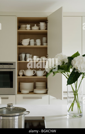 Ouvrir l'armoire dans la cuisine avec vaisselle décoration hydrangea Banque D'Images