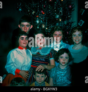 Photo de famille des années 1950, 7 enfants posant pour le portrait le jour de Noël à la maison dans le salon. 'Old Family photos' photos américaines vintage, Noël vintage Banque D'Images