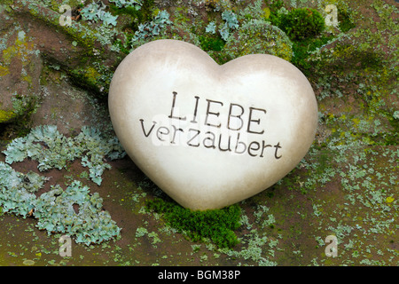 Coeur de pierre avec les mots 'Liebe verzaubert', l'allemand pour 'Amour' enchante Banque D'Images