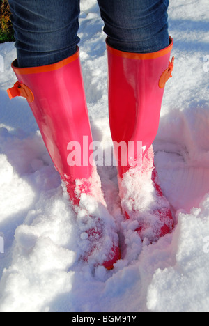 Une paire de bottes rose vif brillant dans la neige. 2010. Banque D'Images