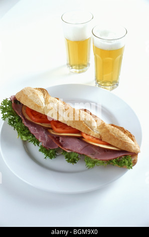 Sandwich à la salade de jambon et tomate avec deux bières Banque D'Images