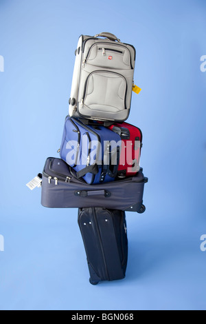 Cinq valises empilées avec tags prêt à vérifier. Banque D'Images