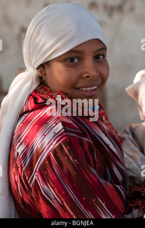 Souriante jeune fille égyptienne avec des yeux en amandes, foulard et oreilles percées. Banque D'Images