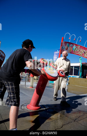 Homme plus âgé de rire de jeune garçon se mettre à l'eau à la machine à coke soak Universal Studios Hollywood Los Angeles, États-Unis. Banque D'Images