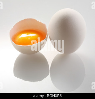 Oeuf blanc et demi oeufs sur un fond blanc. Banque D'Images