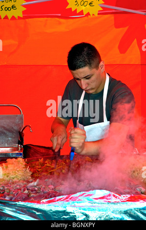 Arles, France - jeune homme chef, cuisine des spécialités locales sur la rue pendant la Feria, les adolescents boucher français Banque D'Images