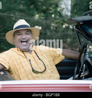 Portrait d'un homme assis dans une voiture décapotable et rire Banque D'Images