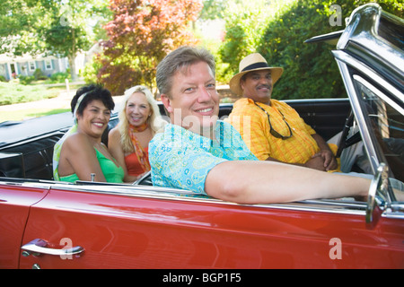 Portrait de deux couples assis sur une voiture décapotable Banque D'Images