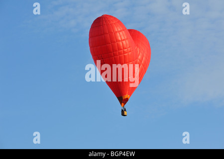 Aérostiers / Aéronautes battant en forme de coeur rouge en ballon à air chaud au cours de la réunion de la montgolfière Banque D'Images
