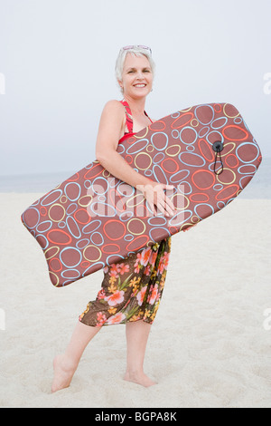 Portrait of a young woman holding a body-board sur la plage Banque D'Images