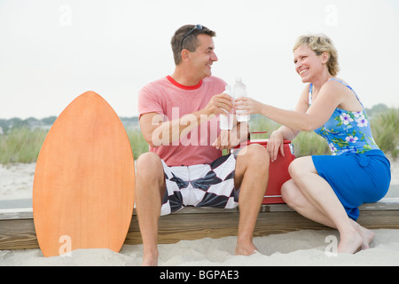 Mature couple toasting with avec des bouteilles d'eau et à la recherche à l'autre Banque D'Images