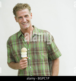 Portrait of a young man holding an ice cream cone Banque D'Images