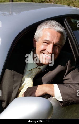 Young handsome man sitting in car smiling Banque D'Images