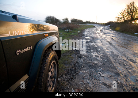 Jeep Cherokee et hors route piste dans la neige, inondé les sillons de roues Banque D'Images