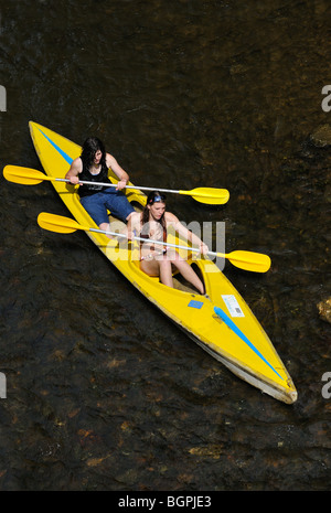 Deux kayakistes kayak / canoë kayak / jaune en canoë sur la rivière Lesse dans les Ardennes Belges, Belgique Banque D'Images